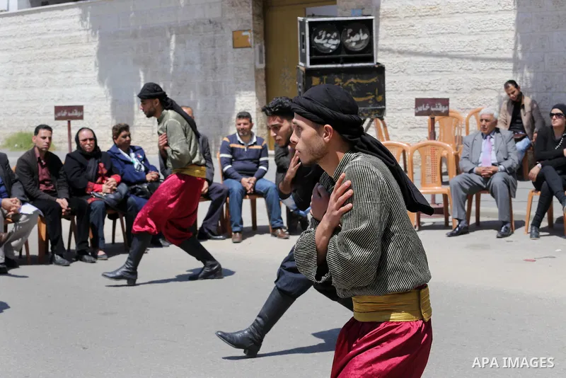 Palestinians youth participate in dancing of "Dabka" during a protest marking Palestinian Prisoners' Day in front of Red cross office in Gaza City April 14, 2016. Photo by Mohammed Asad