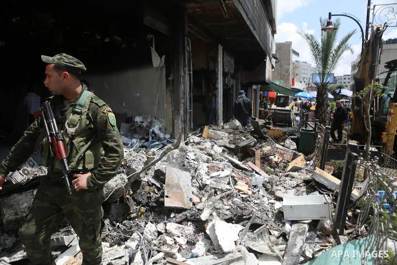 A member of Palestinian security forces walks outside at a money changer in the Palestinian political capital Ramallah after it was raided by Israeli forces, blowing up a safe and sparking a fire, early on April 14, 2016...