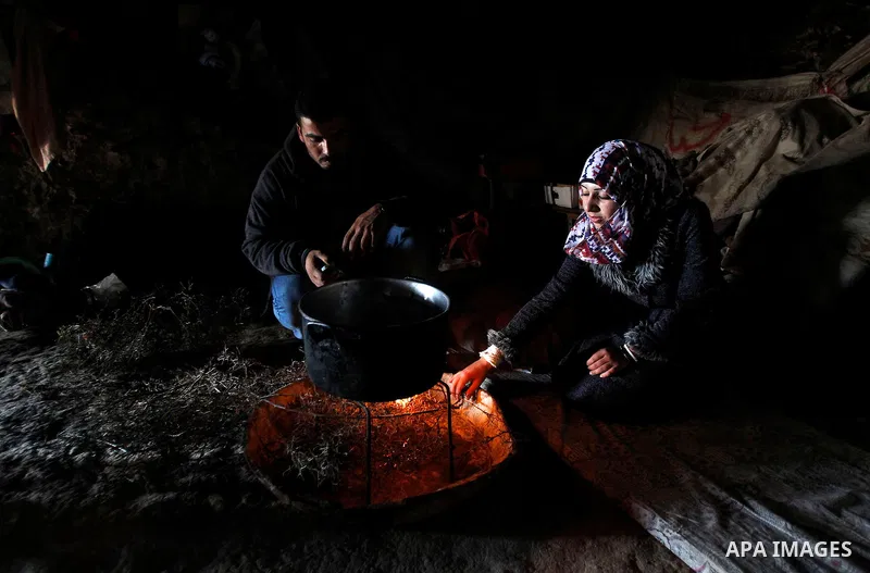 A Palestinian woman of Hawamdeh family cooks inside a cave she lives in, in West Bank village of Mufagara, south of Hebron on April 14, 2016. Photo by Wisam Hashlamoun
