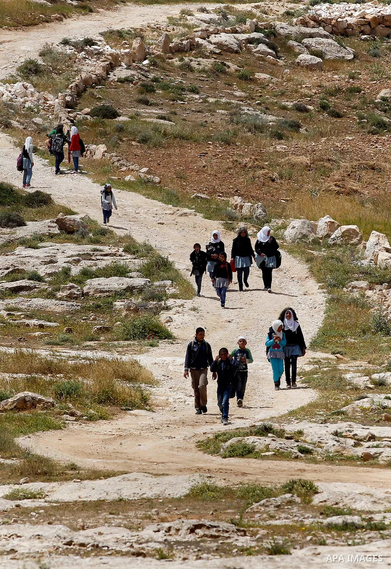 Palestinian students walk at street in West Bank village of Mufagara, south of Hebron on April 14, 2016. Photo by Wisam Hashlamoun