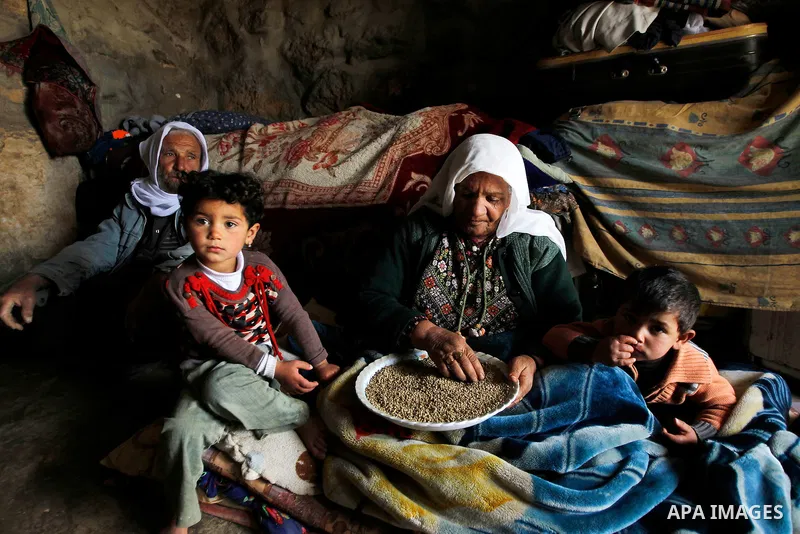 Palestinian members of Hawamdeh family sit a cave they live in, in West Bank village of Mufagara, south of Hebron on April 14, 2016. Photo by Wisam Hashlamoun