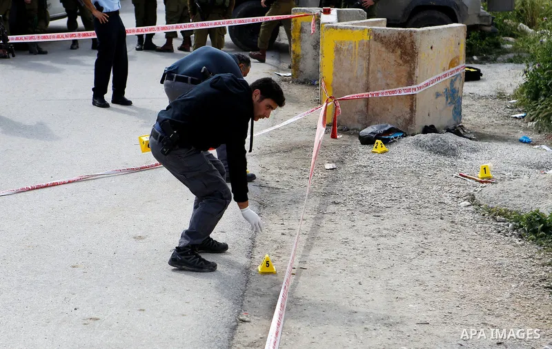 Israeli forces inspect the scene where a Palestinian, whom the Israeli military said attacked Israeli soldiers with an ax, was shot dead at the entrance of Arroub refugee camp, north of the West Bank city of Hebron April...