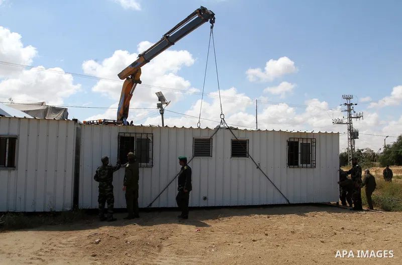 Palestinian workers place containers as new sites for Palestinian security forces in front of the Gaza-Egypt border in Rafah in the southern Gaza Strip, on April 14, 2016. Senior Hamas leader Ismail Haniyeh confirmed tha...