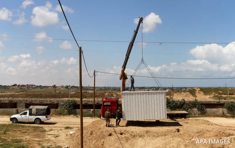 Palestinian workers place containers as new sites for Palestinian security forces in front of the Gaza-Egypt border in Rafah in the southern Gaza Strip, on April 14, 2016. Senior Hamas leader Ismail Haniyeh confirmed tha...