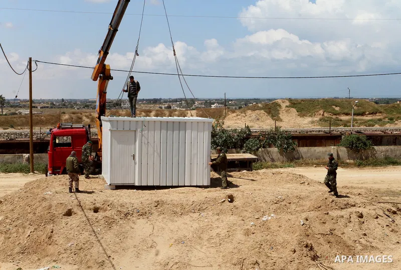 Palestinian workers place containers as new sites for Palestinian security forces in front of the Gaza-Egypt border in Rafah in the southern Gaza Strip, on April 14, 2016. Senior Hamas leader Ismail Haniyeh confirmed tha...