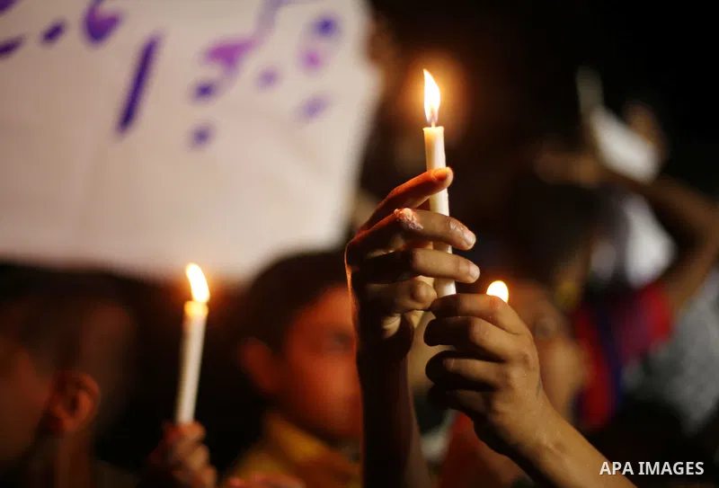 Palestinian children hold placards and light candles during a protest against a power cut in Gaza city on April 14, 2016. Photo by Mohammed Asad