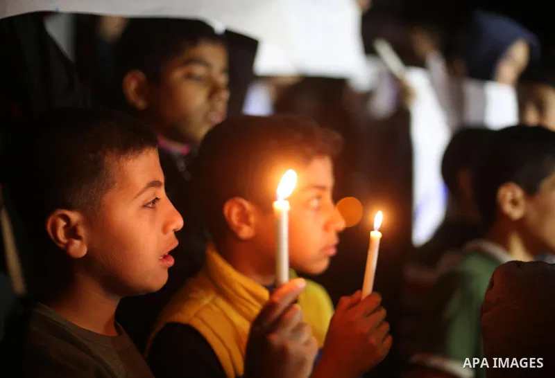 Palestinian children hold placards and light candles during a protest against a power cut in Gaza city on April 14, 2016. Photo by Mohammed Asad
