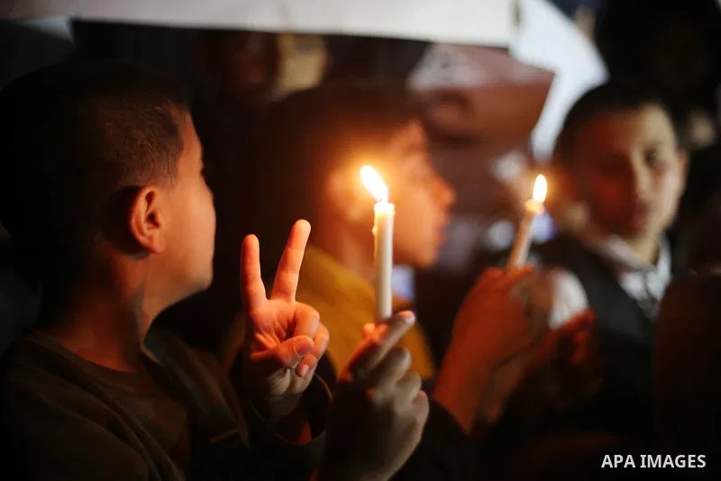 Palestinian children hold placards and light candles during a protest against a power cut in Gaza city on April 14, 2016. Photo by Mohammed Asad