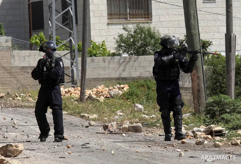 Israeli security forces take aim as they hold a position during clashes with Palestinian protesters following a weekly demonstration against the expropriation of Palestinian land by Israel in the village of Kfar Qaddum,...