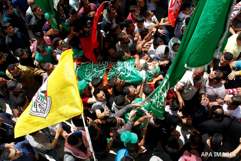 Mourners carry the body of Palestinian Ibrahim al-Gharooz Baradeah, who was killed the day before in a reported attack with an axe on an Israeli soldier, during his funeral on April 16, 2016 at al-Arroub Palestinian refu...