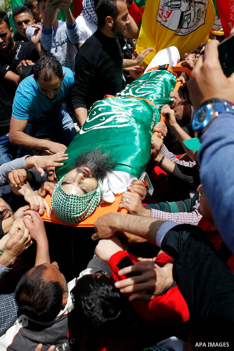 Mourners carry the body of Palestinian Ibrahim al-Gharooz Baradeah, who was killed the day before in a reported attack with an axe on an Israeli soldier, during his funeral on April 16, 2016 at al-Arroub Palestinian refu...