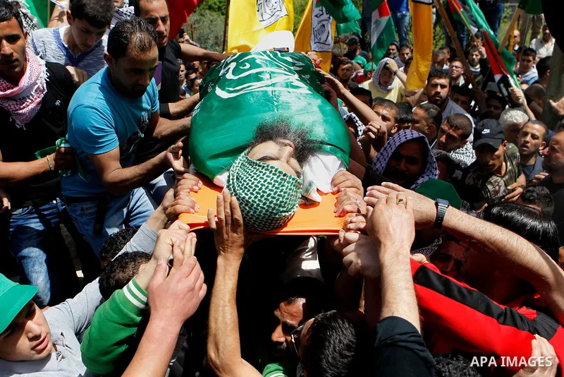 Mourners carry the body of Palestinian Ibrahim al-Gharooz Baradeah, who was killed the day before in a reported attack with an axe on an Israeli soldier, during his funeral on April 16, 2016 at al-Arroub Palestinian refu...