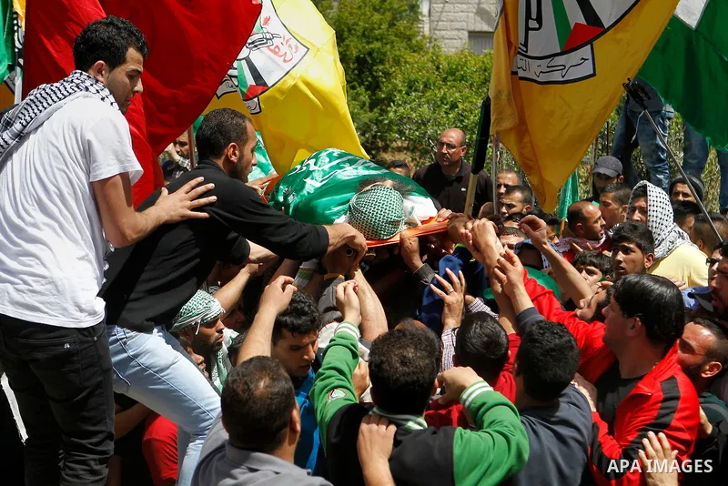 Mourners carry the body of Palestinian Ibrahim al-Gharooz Baradeah, who was killed the day before in a reported attack with an axe on an Israeli soldier, during his funeral on April 16, 2016 at al-Arroub Palestinian refu...