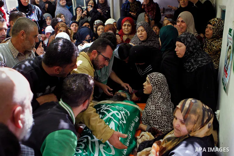 Mourners carry the body of Palestinian Ibrahim al-Gharooz Baradeah, who was killed the day before in a reported attack with an axe on an Israeli soldier, during his funeral on April 16, 2016 at al-Arroub Palestinian refu...