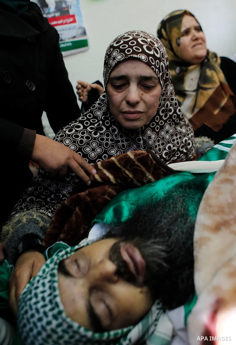 A sister of Palestinian Ibrahim al-Gharooz Baradeah, who was killed the day before in a reported attack with an axe on an Israeli soldier, mourns next to his body during his funeral on April 16, 2016 at al-Arroub Palesti...