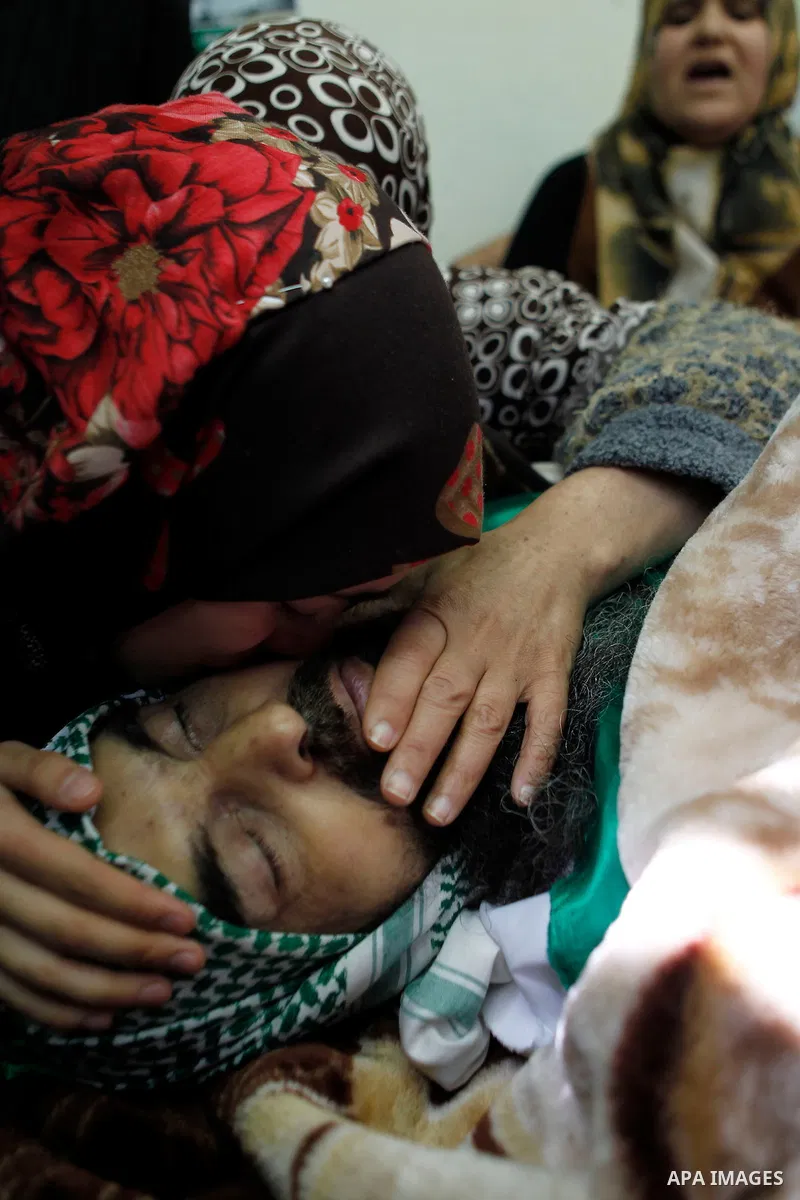 Relatives of Palestinian Ibrahim al-Gharooz Baradeah, who was killed the day before in a reported attack with an axe on an Israeli soldier, mourn during his funeral on April 16, 2016 at al-Arroub Palestinian refugee camp...