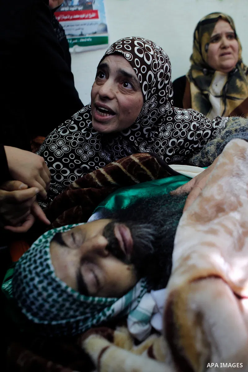 A sister of Palestinian Ibrahim al-Gharooz Baradeah, who was killed the day before in a reported attack with an axe on an Israeli soldier, mourns next to his body during his funeral on April 16, 2016 at al-Arroub Palesti...