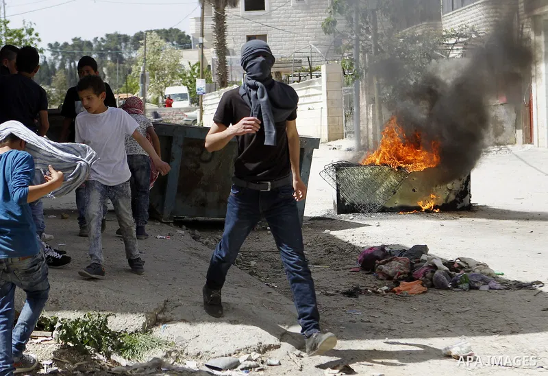 Palestinian protesters hurl stones towards Israeli troops during clashes in Arroub refugee camp north of the West Bank city of Hebron April 16, 2016. Photo by Wisam Hashlamoun