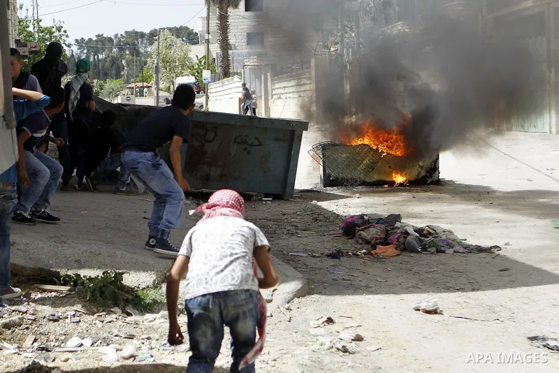 Palestinian protesters hurl stones towards Israeli troops during clashes in Arroub refugee camp north of the West Bank city of Hebron April 16, 2016. Photo by Wisam Hashlamoun