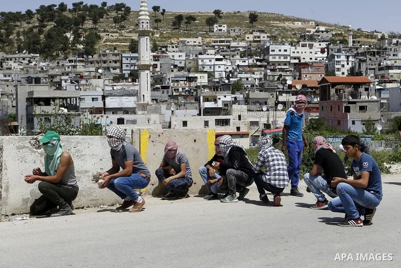 Palestinian protesters hurl stones towards Israeli troops during clashes in Arroub refugee camp north of the West Bank city of Hebron April 16, 2016. Photo by Wisam Hashlamoun
