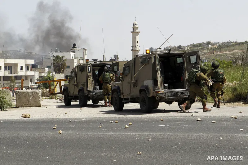 Palestinian protesters hurl stones towards Israeli troops during clashes in Arroub refugee camp north of the West Bank city of Hebron April 16, 2016. Photo by Wisam Hashlamoun