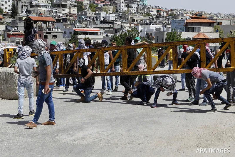 Palestinian protesters hurl stones towards Israeli troops during clashes in Arroub refugee camp north of the West Bank city of Hebron April 16, 2016. Photo by Wisam Hashlamoun