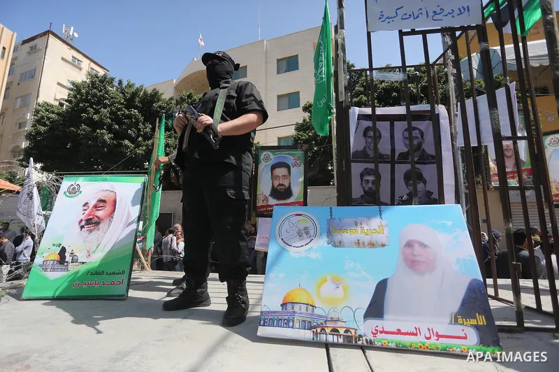 Members of the Ezzedine al-Qassam Brigades, the military wing of the Palestinian Islamist movement Hamas, stand next to mock jails during a rally marking Palestinian Prisoner Day in Gaza City on April 17, 2016. Photo by...