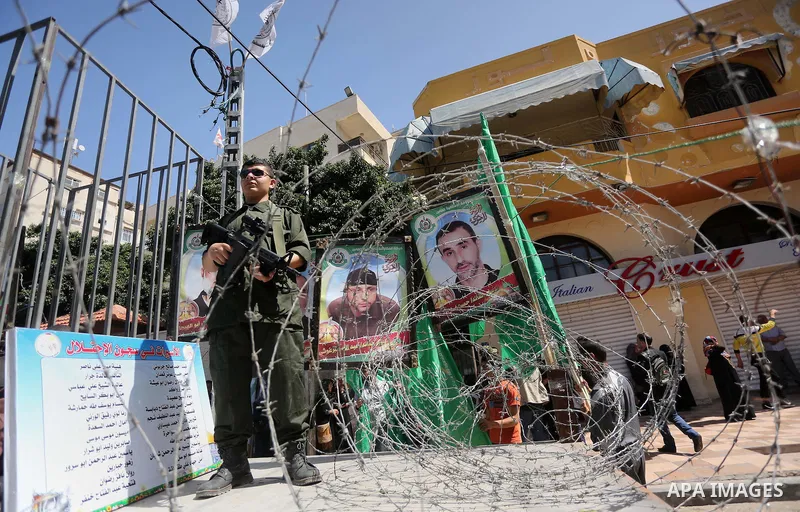 Members of the Ezzedine al-Qassam Brigades, the military wing of the Palestinian Islamist movement Hamas, stand next to mock jails during a rally marking Palestinian Prisoner Day in Gaza City on April 17, 2016. Photo by...