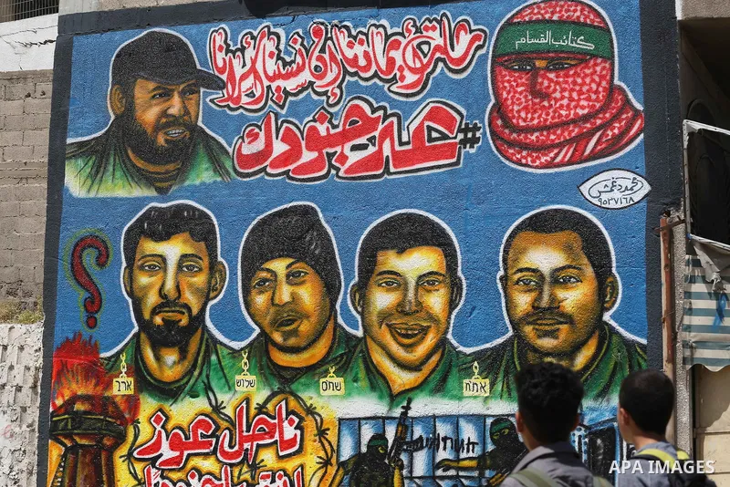 Palestinian men look graffiti marking Palestinian Prisoner Day in Gaza City on April 17, 2016. Photo by Mohammed Asad