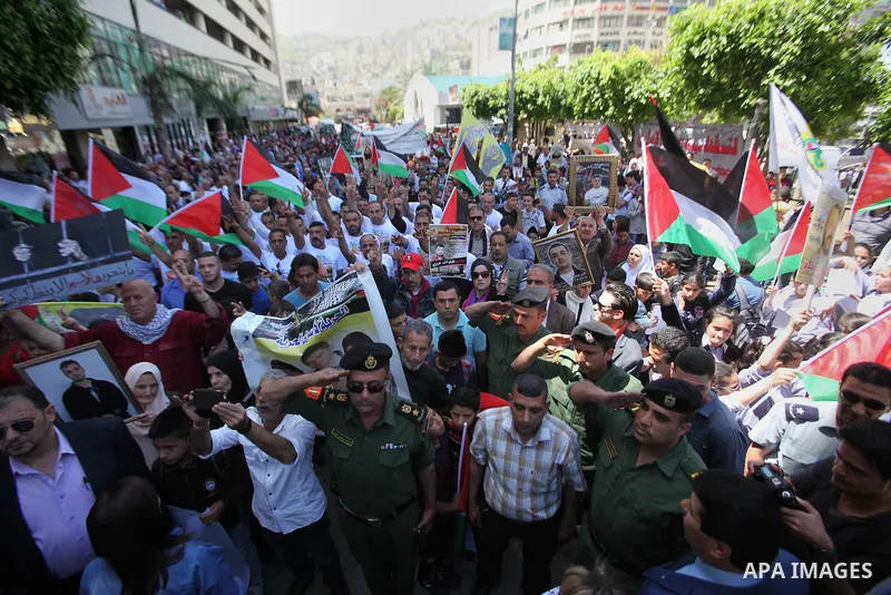 Palestinians hold pictures of Palestinians detained in Israeli prisons during a demonstration to mark Palestinian Prisoner Day in the West Bank city of Nablus on April 17, 2016. Photo by Nedal Eshtayah