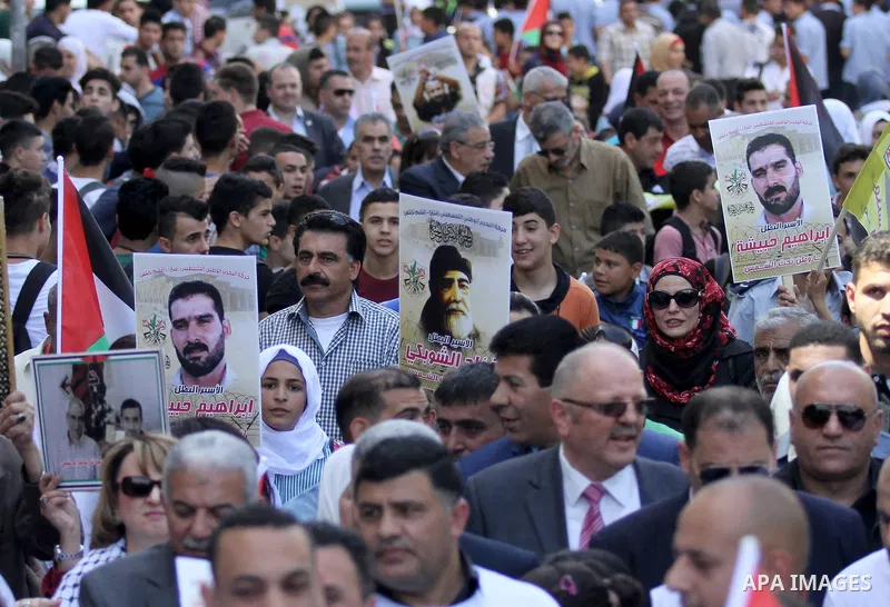 Palestinians hold pictures of Palestinians detained in Israeli prisons during a demonstration to mark Palestinian Prisoner Day in the West Bank city of Nablus on April 17, 2016. Photo by Nedal Eshtayah