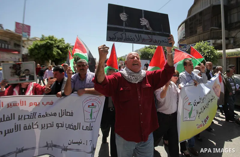 Palestinians hold pictures of Palestinians detained in Israeli prisons during a demonstration to mark Palestinian Prisoner Day in the West Bank city of Nablus on April 17, 2016. Photo by Nedal Eshtayah