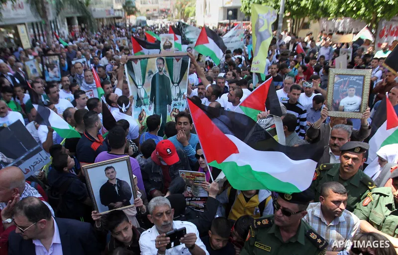Palestinians hold pictures of Palestinians detained in Israeli prisons during a demonstration to mark Palestinian Prisoner Day in the West Bank city of Nablus on April 17, 2016. Photo by Nedal Eshtayah