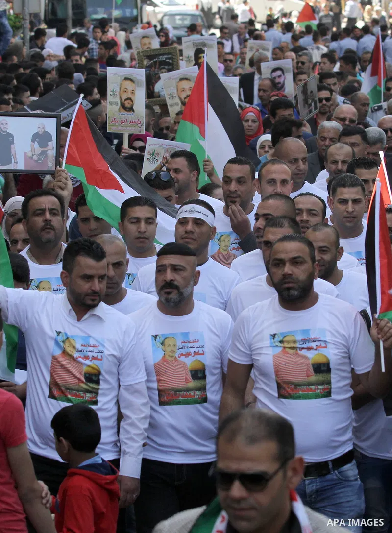 Palestinians hold pictures of Palestinians detained in Israeli prisons during a demonstration to mark Palestinian Prisoner Day in the West Bank city of Nablus on April 17, 2016. Photo by Nedal Eshtayah