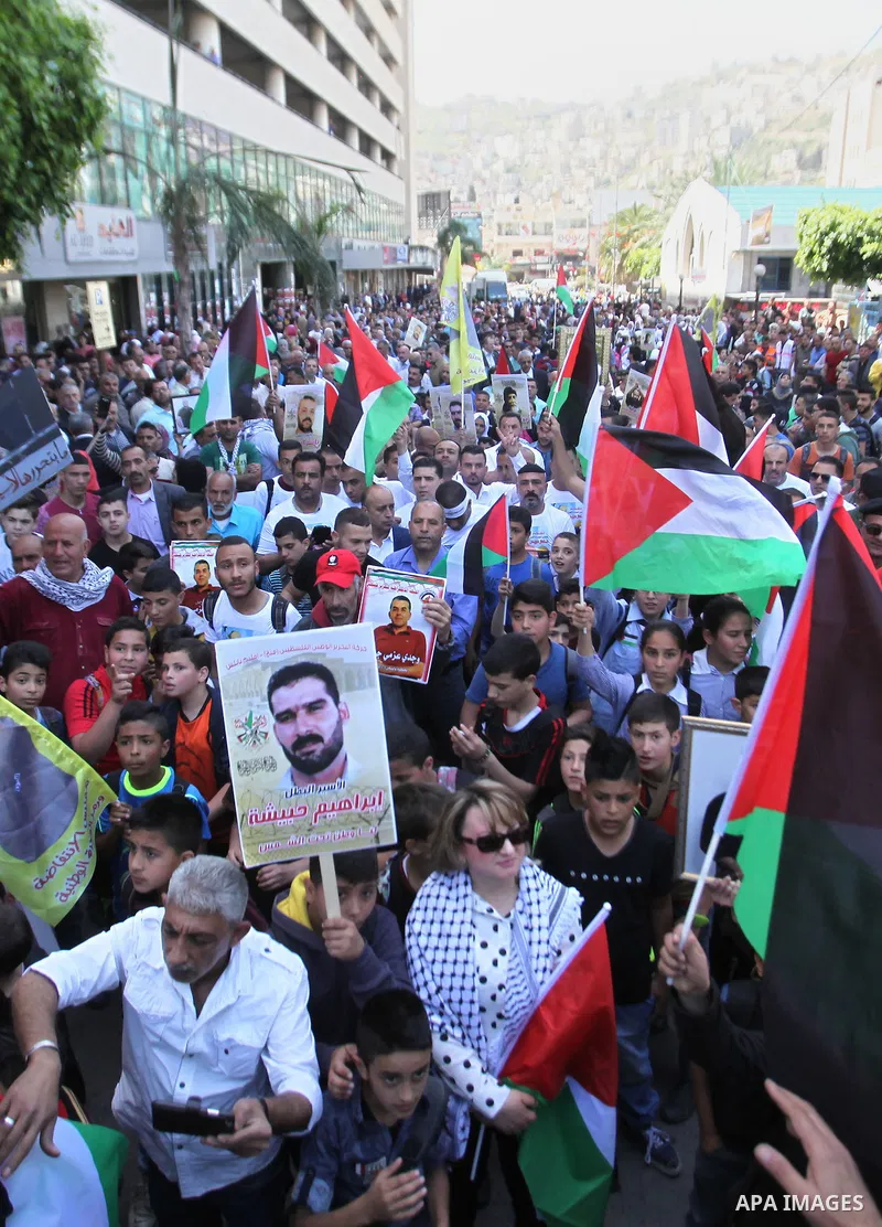 Palestinians hold pictures of Palestinians detained in Israeli prisons during a demonstration to mark Palestinian Prisoner Day in the West Bank city of Nablus on April 17, 2016. Photo by Nedal Eshtayah