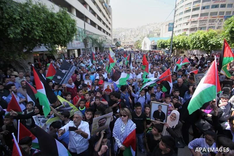 Palestinians hold pictures of Palestinians detained in Israeli prisons during a demonstration to mark Palestinian Prisoner Day in the West Bank city of Nablus on April 17, 2016. Photo by Nedal Eshtayah