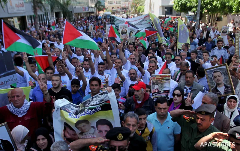Palestinians hold pictures of Palestinians detained in Israeli prisons during a demonstration to mark Palestinian Prisoner Day in the West Bank city of Nablus on April 17, 2016. Photo by Nedal Eshtayah