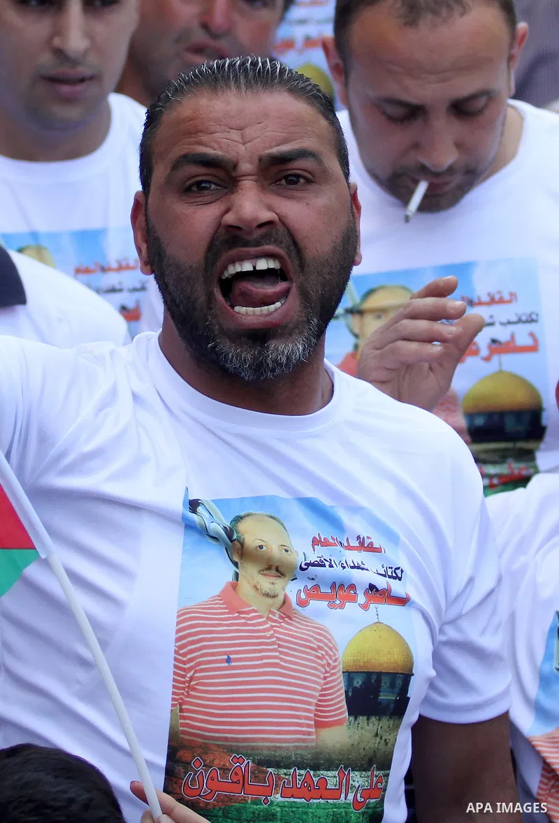 Palestinians hold pictures of Palestinians detained in Israeli prisons during a demonstration to mark Palestinian Prisoner Day in the West Bank city of Nablus on April 17, 2016. Photo by Nedal Eshtayah