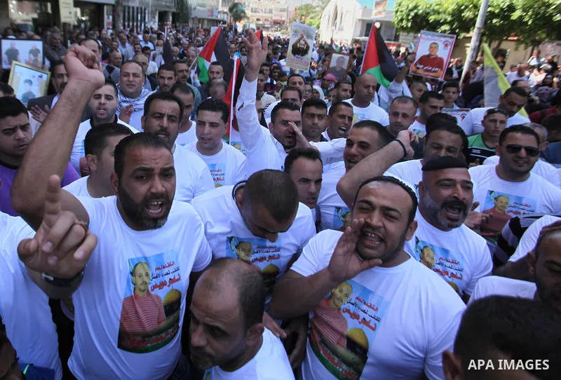 Palestinians hold pictures of Palestinians detained in Israeli prisons during a demonstration to mark Palestinian Prisoner Day in the West Bank city of Nablus on April 17, 2016. Photo by Nedal Eshtayah
