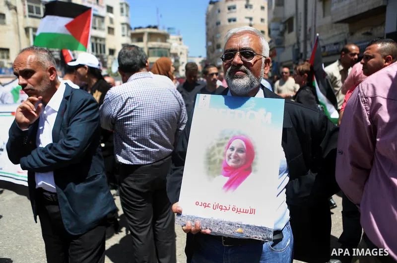 Palestinians hold pictures of Palestinians detained in Israeli prisons during a demonstration to mark Palestinian Prisoner Day in the West Bank city of Ramallah on April 17, 2016. Photo by Shadi Hatem