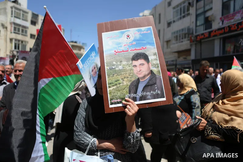 Palestinians hold pictures of Palestinians detained in Israeli prisons during a demonstration to mark Palestinian Prisoner Day in the West Bank city of Ramallah on April 17, 2016. Photo by Shadi Hatem