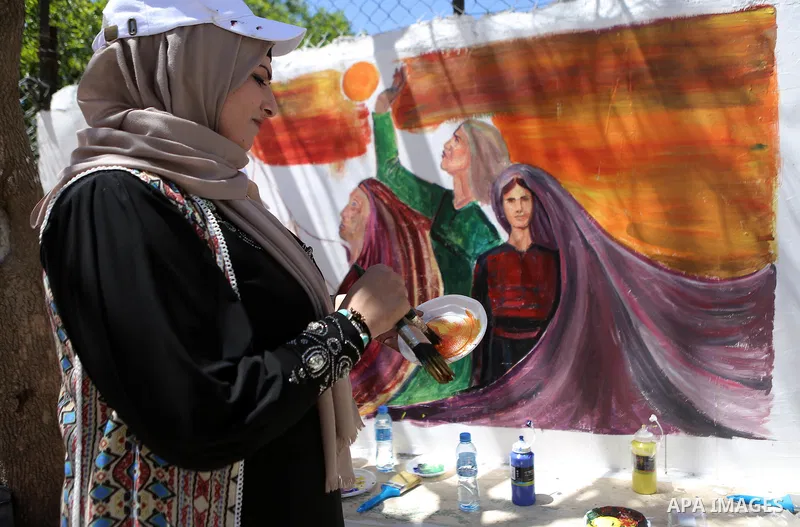 A Palestinian artist paints graffiti at school to mark Palestinian Prisoner Day in the West Bank city of Ramallah on April 17, 2016. Photo by Shadi Hatem