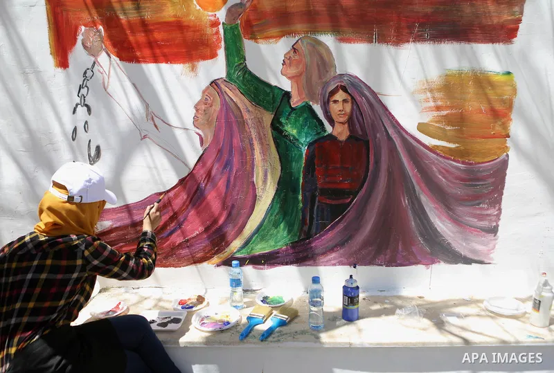 A Palestinian artist paints graffiti at school to mark Palestinian Prisoner Day in the West Bank city of Ramallah on April 17, 2016. Photo by Shadi Hatem