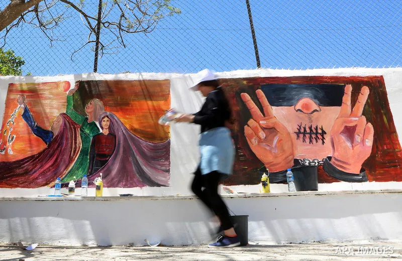 A Palestinian artist paints graffiti at school to mark Palestinian Prisoner Day in the West Bank city of Ramallah on April 17, 2016. Photo by Shadi Hatem