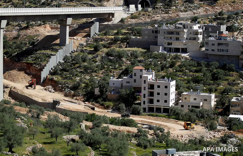 Israeli workers place a new section of Israel's separation concrete barrier in the Cremisan Valley, adjacent to the Christian Palestinian town of Beit Jala on April 17, 2016. The original route of the barrier was slated...