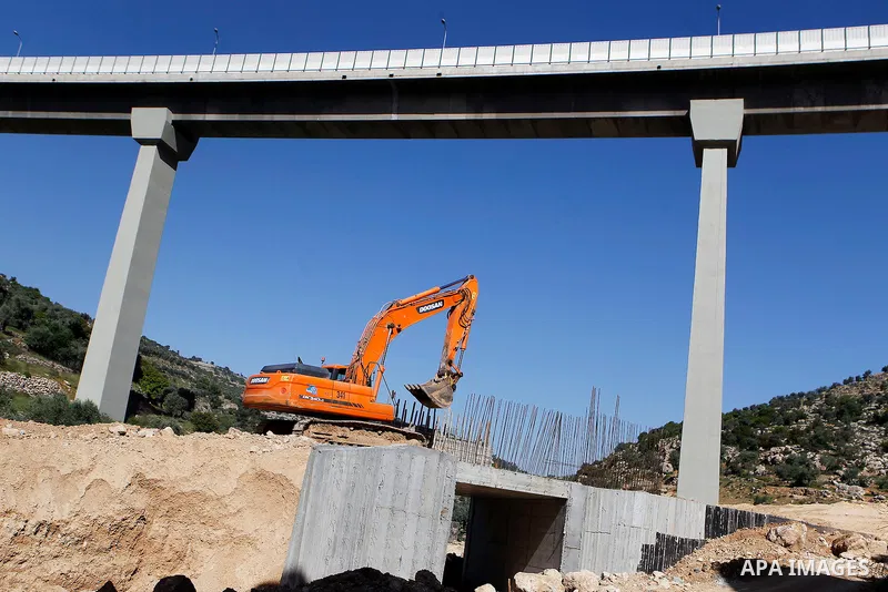 Israeli workers place a new section of Israel's separation concrete barrier in the Cremisan Valley, adjacent to the Christian Palestinian town of Beit Jala on April 17, 2016. The original route of the barrier was slated...