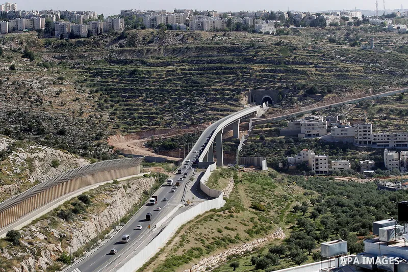 Israeli workers place a new section of Israel's separation concrete barrier in the Cremisan Valley, adjacent to the Christian Palestinian town of Beit Jala on April 17, 2016. The original route of the barrier was slated...