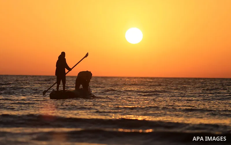 Palestinains ride a boat during sunset at the beach of the Mediterranean sea on the coast of Gaza city on April 17, 2016. Photo by Yasser Qudih