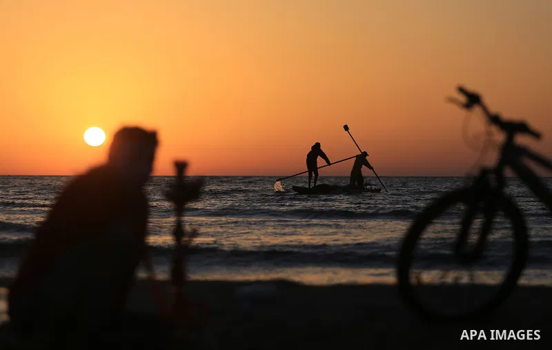 Palestinains ride a boat during sunset at the beach of the Mediterranean sea on the coast of Gaza city on April 17, 2016. Photo by Yasser Qudih