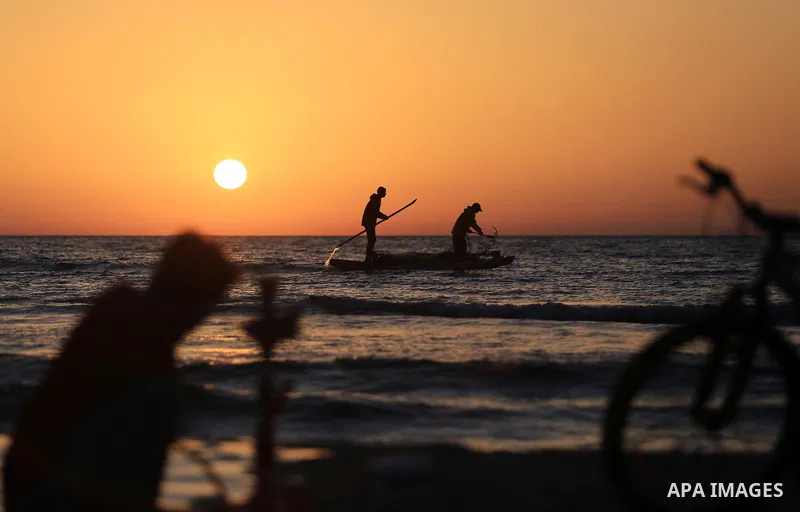 Palestinains ride a boat during sunset at the beach of the Mediterranean sea on the coast of Gaza city on April 17, 2016. Photo by Yasser Qudih